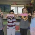 Captain Strong Primary School third graders hold up bookmarks with anti-bullying messages
